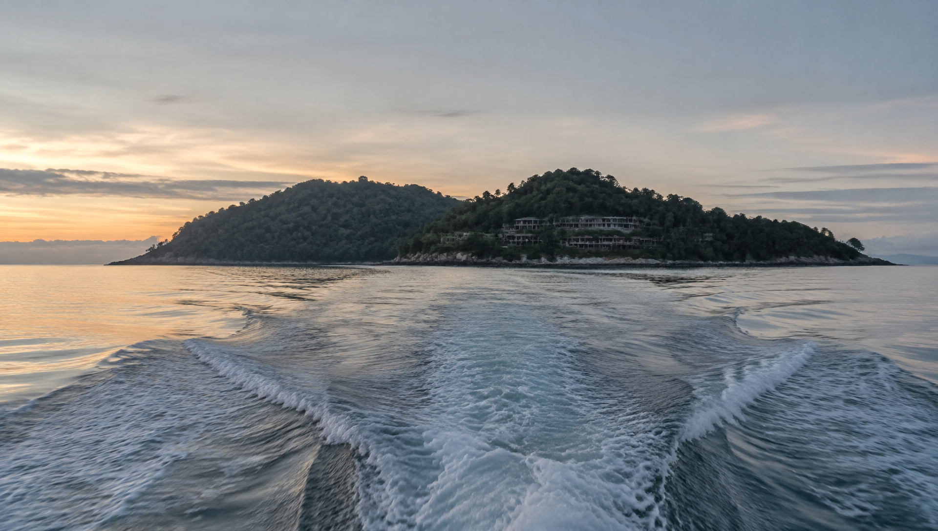 Illustration: a boat wake leading toward a forested island at first light